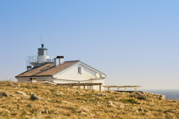 Fototapeta na wymiar Leuchtturm mit Haus an der Küste