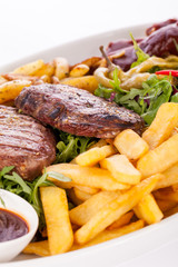 Platter of mixed meats, salad and French fries
