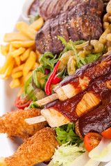 Platter of mixed meats, salad and French fries