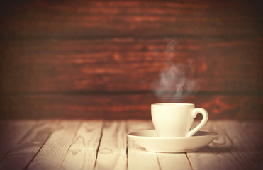 Cup of coffee on wooden table and background.
