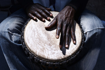 Close up of hands of a black man playing a drum - obrazy, fototapety, plakaty