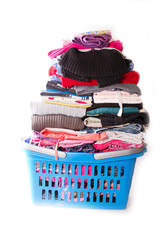 blauer Wäschekorb voller Buntwäsche auf weißem Hintergrund