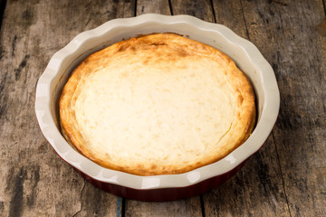 Fresh baked cheesecake on wooden table.