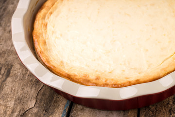 Fresh baked cheesecake on wooden table.
