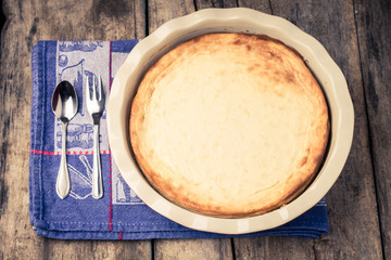 Fresh baked cheesecake on wooden table.