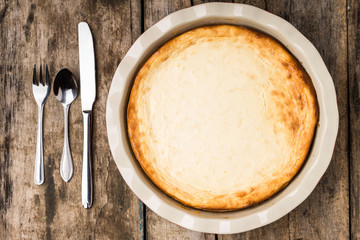 Fresh baked cheesecake on wooden table.