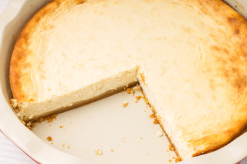 Fresh baked cheesecake with cut of piece.