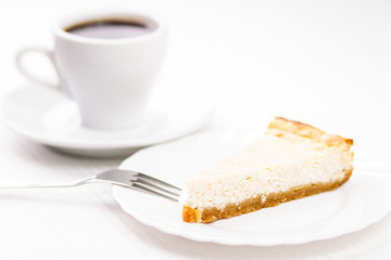 Piece of fresh baked cheesecake with cup of espesso coffee