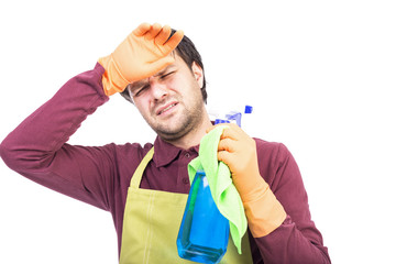 Young man with apron and gloves holding tired to clean