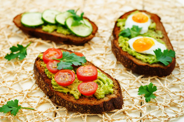 rye sandwiches and mashed avocado, eggs, tomatoes and cucumbers