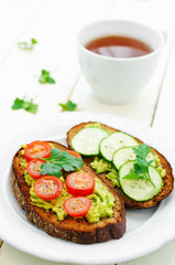 rye sandwiches and mashed avocado, eggs, tomatoes and cucumbers