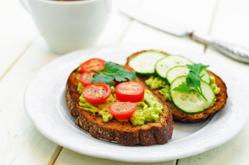 rye sandwiches and mashed avocado, eggs, tomatoes and cucumbers