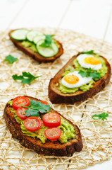 rye sandwiches and mashed avocado, eggs, tomatoes and cucumbers