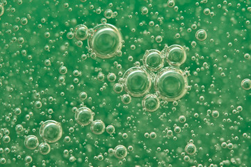 Macro Oxygen bubbles in water on a green background
