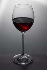 Glass of red wine on grey
