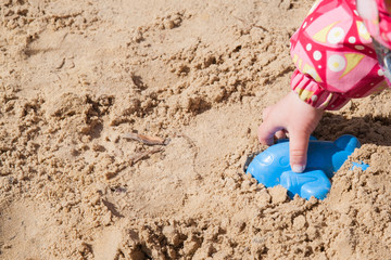 Fototapeta na wymiar Children's hand in the sandbox