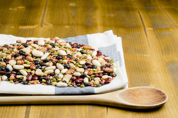 legumes in a dish on wood, with spoon, close up, background