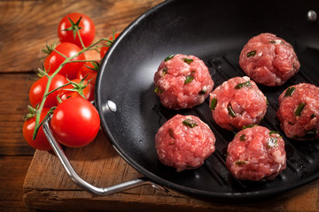 Raw meatballs wih cherry tomato