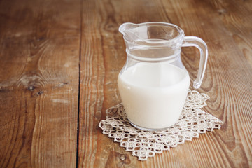 Obraz na płótnie Canvas milk in jug on wooden surface