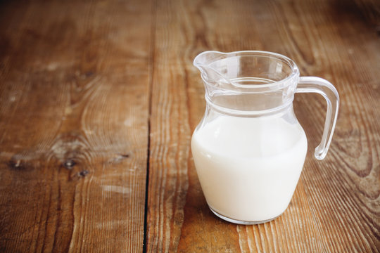 milk in jug on wooden surface