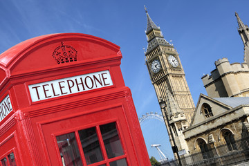 Fototapeta na wymiar London red telephone box booth with westminster houses of parliament building and Big Ben clock tower in the background photo