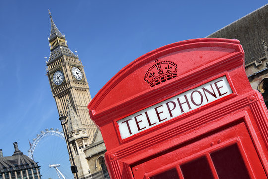 London red telephone box booth with westminster houses of parliament building and Big Ben clock tower in the background photo