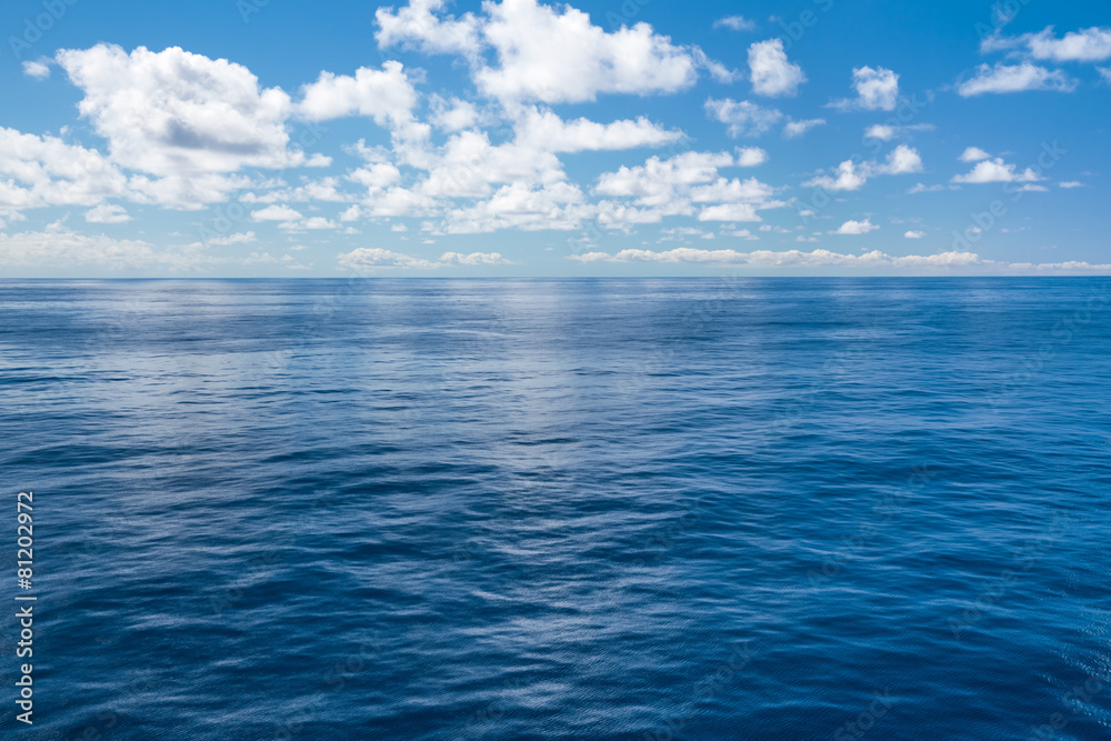 Wall mural Deep blue ocean with clouds in the sky