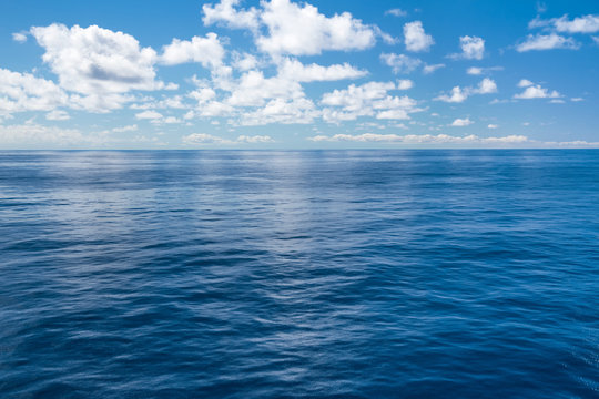 Fototapeta Deep blue ocean with clouds in the sky