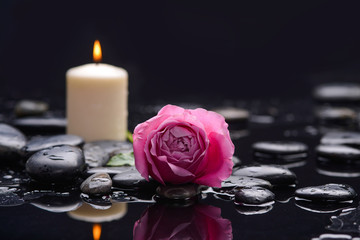 Beautiful rose with white candle and therapy stones