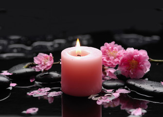 Obraz na płótnie Canvas Still life with cherry blossom with candle on black stones