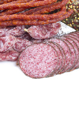 smoked salami, sausages and proschiutto isolated on white