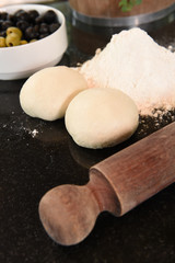 Small balls of fresh pizza dough on wooden board.
