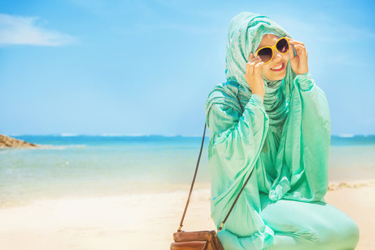 pretty girl on a beach wearing traditional muslim costume