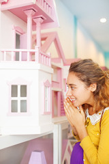 Fototapeta na wymiar woman peeking inside a toy house