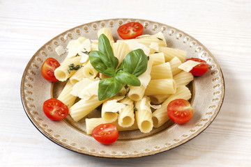 Pasta on plate with fresh basil leaves