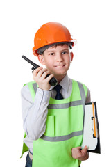 the young boy in hardhat and vest stands with portable radio
