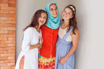 three friends of different religions standing happily together