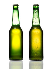 Bottles of beer with water drops on white background