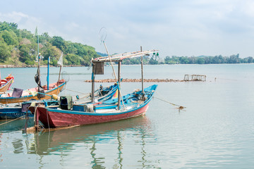 A fishing boat is moored at a fishing village, in the sea.
