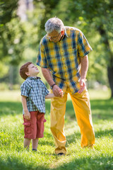 Grandfather and grandson talking in park