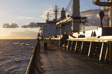 Cargo ship underway at sunset