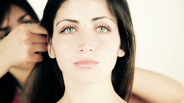 Woman getting hairstyle by female hairstylist closeup