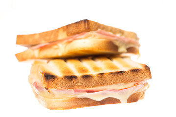 Zwei Schinken Käse Toasts übereinander auf weißem Hintergrund