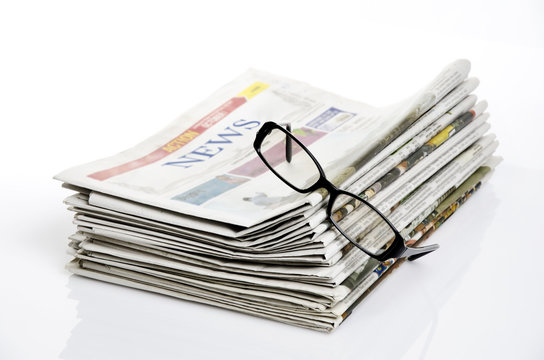 bird eye view of glasses on newspapers against white background