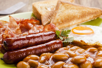 Full english breakfast with bacon, sausage, fried egg, baked bea