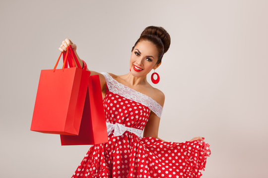 Happy Woman Holding Up Shopping Bags. Pin-up retro style.