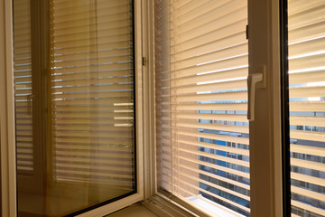 Jalousien als Sonnenschutz am Fenster