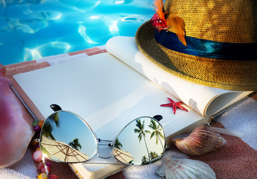 art Straw hat , book and Sunglasses on the beach