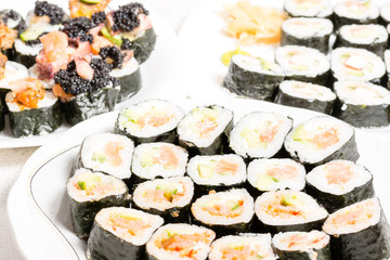 Homemade sushi in a white plate with wasabi and ginger