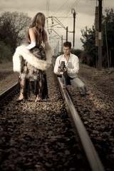 Young attractive fashionable couple outdoors near train tracks